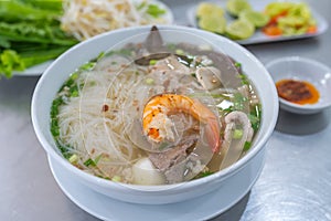 Tasty Vietnamese rice noodle soup served with green vegetables