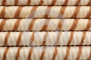 Tasty wafer roll sticks as background, top view.