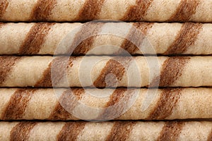 Tasty wafer roll sticks as background, top view.