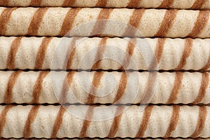 Tasty wafer roll sticks as background, top view.