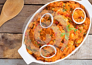 tasty yam pottage decorated with green spices and onion rings photo