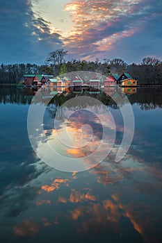 Tata, Hungary - Beautiful sunset over wooden fishing cottages on a small island at Lake Derito