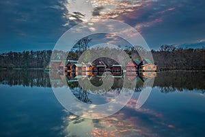 Tata, Hungary - Beautiful sunset over wooden fishing cottages on a small island at lake Derito Derito to in November