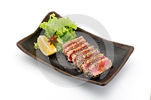 Tataki & x28;tuna fillet& x29; on a black plate