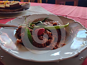 Tatar steak - raw milled beef meat in the plate on the table.