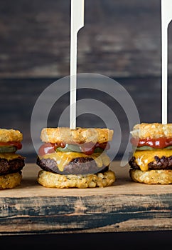 Tater and beef appetizer slider skewers on a wooden board.