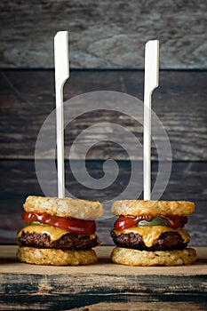 Tater and beef slider skewers on a wooden board, ready for eating.