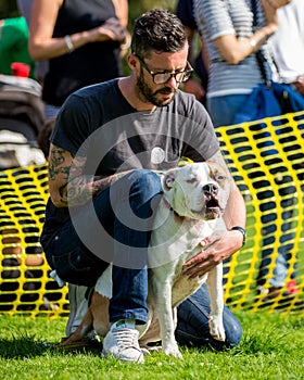 A tatooed man with a dog in the park at a dog show
