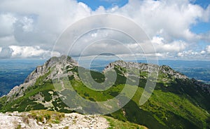 Tatra mountains in Poland, green hill, valley and rocky peak in the sunny day with clear blue sky