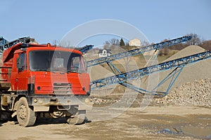 Tatra`s red dump truck in the background of rubble sorting. Elements of equipment for the extraction and sorting of rubble.