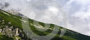 Paragliding - Paragliders flying over a mountain slope. Tatra Mountains