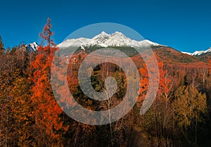 Tatranske Matliare, Slovakia - Aerial view of the snowy mountains of Lomnicky Peak in the High Tatras with autumn foliage