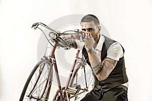 Tattoed elegant man cycling on bicycle