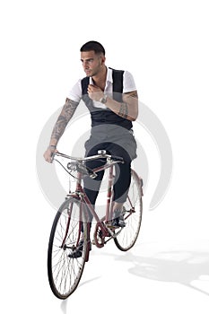 Tattoed elegant man riding his bicycle in istudio