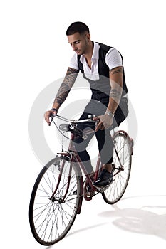 Tattoed elegant man riding his bicycle in istudio