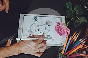 Tattoo art digital process on ipad. Tattoo artist hands holding Apple Pencil and drawing on iPad Pro in Procreate. Kropivnitskiy,