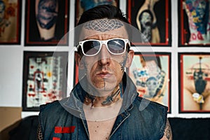 Tattoo artist in denim vest and sunglasses