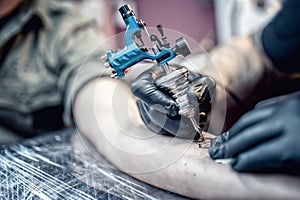 Tattoo artist drawing on client with special tools