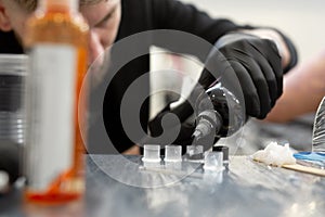 Tattoo artist prepares tools and ink before working in a tattoo parlor.