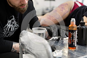 Tattoo artist prepares tools and ink before working in a tattoo parlor.