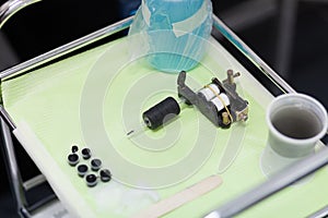 Tattoo ink and gun on table