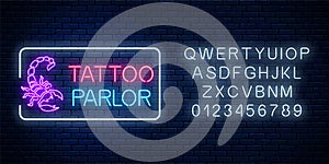 Tattoo parlor glowing neon signboard with scorpio emblem and alphabet. Tattoo salon sign in rectangle frame