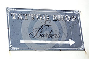 Tattoo Shop & Barbers sign on a white wall