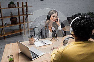 tattooed brunette interviewer in headphones holding