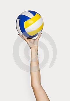 Tattooed hand holding volleyball isolated