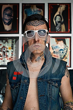 Tattooed man in denim vest and sunglasses