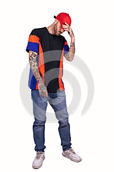 Tattooed rap singer posing in studio wearing red cap
