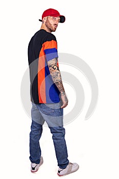 Tattooed rap singer posing in studio wearing red cap