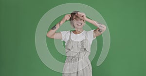 Tattooed woman dancing over green background