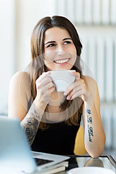 Tattooed woman enjoying a cup of coffee