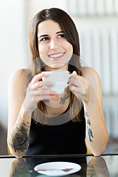 Tattooed woman enjoying a cup of coffee