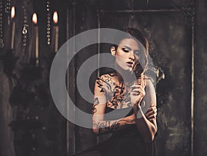 Tattooed woman in spooky interior