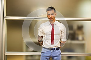 Tattooed young male office worker standing