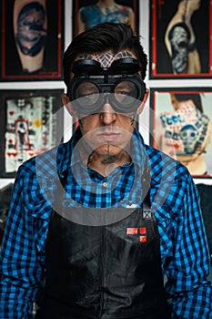 Tattooist in welder glasses and leather apron photo