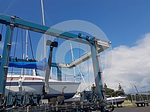Tauranga Marina hardstand travel lift with yacht hoisted for mai