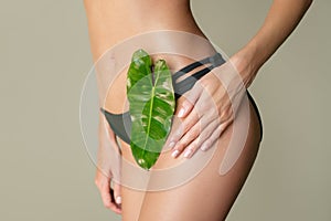 A taut female figure with green leaf. Health care beauty