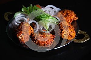 Tawa fish a punjabi recipe as starters served in north indian style plate nicely garnished with onion rings and photographed