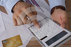 Tax accountant with calculator working at wooden table, closeup