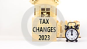 Tax changes 2023 symbol. Concept words Tax changes 2023 on wooden blocks on a beautiful white table white background. Black alarm