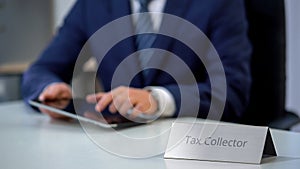 Tax collector using tablet pc with database of debtors with bad credit history