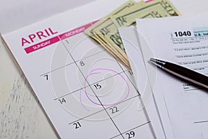 Tax Day , dollars and form 1040 income tax form showing tax day for April Calendar with words