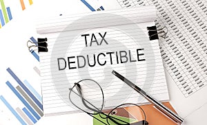 TAX DEDUCTIBLE text on the chart , office supplies, business concept photo