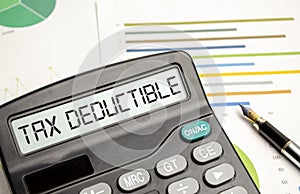 TAX DEDUCTIBLE word on calculator. Business and tax concept