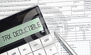 TAX DEDUCTIBLE word on calculator. Business and tax concept. Tax form
