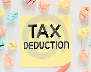 TAX Deduction words written on a small yellow piece of paper