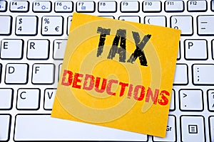 Tax Deductions. Business concept for Finance Incoming Tax Money Deduction written on sticky note paper on the white keyboard backg